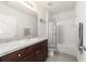 Charming bathroom with a vanity featuring dark wood cabinets, a framed mirror, and a shower-tub combination at 9785 Pepper Tree Trl, Wildwood, FL 34785