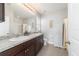 Bright bathroom features a double sink vanity with granite countertop and a matching accent cabinet at 9785 Pepper Tree Trl, Wildwood, FL 34785