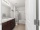 Well-lit bathroom featuring a vanity with dark wood cabinets, a framed mirror, and a shower-tub combination at 9785 Pepper Tree Trl, Wildwood, FL 34785