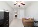 Bright bedroom with a ceiling fan, brown chair, and neutral-toned walls and carpet at 9785 Pepper Tree Trl, Wildwood, FL 34785
