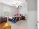 Comfortable bedroom with ceiling fan, window and a bright interior, creating a pleasant and relaxing atmosphere at 9785 Pepper Tree Trl, Wildwood, FL 34785