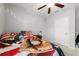 Well-lit bedroom with comfortable furnishings, a ceiling fan and ample natural light from the window at 9785 Pepper Tree Trl, Wildwood, FL 34785