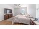 Bright bedroom with wood floors, a ceiling fan, and natural light, creating a comfortable and inviting space at 9785 Pepper Tree Trl, Wildwood, FL 34785