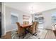 Elegant dining room features a wood table, woven chairs, and natural light with a pool view through sliding glass doors at 9785 Pepper Tree Trl, Wildwood, FL 34785