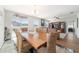 Open-concept dining area flows into the living room, offering woven chairs, natural light and convenient access to the pool at 9785 Pepper Tree Trl, Wildwood, FL 34785