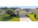 Charming one-story home featuring a well-manicured lawn and attached two-car garage at 9785 Pepper Tree Trl, Wildwood, FL 34785
