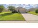 Beautiful one-story home featuring a manicured lawn, a two-car garage, and a well-maintained exterior at 9785 Pepper Tree Trl, Wildwood, FL 34785