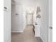 Bright hallway with neutral walls, decorative accents, and tiled floors leading to other rooms at 9785 Pepper Tree Trl, Wildwood, FL 34785