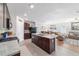 Open-concept kitchen features dark cabinetry, stainless steel appliances, granite countertops, and bar seating at 9785 Pepper Tree Trl, Wildwood, FL 34785
