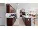 Spacious kitchen with dark cabinets, stainless steel appliances, and granite countertops seamlessly connect to the dining area at 9785 Pepper Tree Trl, Wildwood, FL 34785