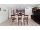 The bright kitchen with island, bar seating, and dark cabinets offers ample counter space for cooking and entertaining at 9785 Pepper Tree Trl, Wildwood, FL 34785