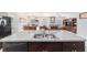 Kitchen island with stainless steel sink and dishwasher overlooks the dining and living areas at 9785 Pepper Tree Trl, Wildwood, FL 34785