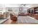 Comfortable living room featuring hardwood floors, plush seating, and natural light from nearby windows at 9785 Pepper Tree Trl, Wildwood, FL 34785