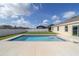 Backyard pool with a lounge chair surrounded by a well-maintained yard and a white fence at 9785 Pepper Tree Trl, Wildwood, FL 34785