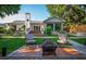A patio with chairs and a fire pit face a backyard with stairs leading up to the home at 4219 Magnolia Ave, Leesburg, FL 34748