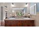 Beautiful bathroom with granite double sinks, wooden cabinets, and vanity mirror at 4219 Magnolia Ave, Leesburg, FL 34748