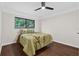 Comfortable bedroom with dark wood floors, neutral walls, a modern ceiling fan, and a view to the backyard at 4219 Magnolia Ave, Leesburg, FL 34748