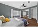 Well-lit bedroom features a ceiling fan, hardwood floors, and a sliding mirror closet at 4219 Magnolia Ave, Leesburg, FL 34748