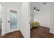 Bright entryway with decorative door and dark wood floors, leading into a bedroom with a ceiling fan at 4219 Magnolia Ave, Leesburg, FL 34748