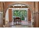 Inviting dining area features a brick archway, wood floors, and sliding glass doors to a beautiful outdoor view at 4219 Magnolia Ave, Leesburg, FL 34748