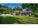 A well-kept lawn accents this brick home, featuring an attached garage, arched entryway, and a partial white perimeter fence at 4219 Magnolia Ave, Leesburg, FL 34748
