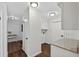Hallway featuring dark wood floors, white walls, modern ceiling lights, and access to the laundry room at 4219 Magnolia Ave, Leesburg, FL 34748