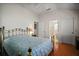 Bright bedroom featuring wood floors, a gold bed frame, and an attached bathroom at 1007 Diego Ct, The Villages, FL 32159