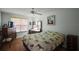 Bedroom with ceiling fan, wood floors, dresser, and window providing natural light at 1007 Diego Ct, The Villages, FL 32159