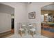 Cozy dining nook featuring white chairs, a glass-top table, and an entrance to the dining room at 1007 Diego Ct, The Villages, FL 32159