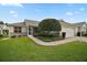 Beautiful home with manicured lawn, a brick driveway, and a two-car garage at 1007 Diego Ct, The Villages, FL 32159