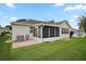 Backyard view featuring an enclosed lanai with windows and a view of the home's exterior at 1007 Diego Ct, The Villages, FL 32159
