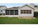 Rear exterior view of the home featuring a screened lanai and green lawn at 1007 Diego Ct, The Villages, FL 32159