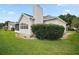 Home exterior featuring white siding, a manicured lawn, chimney, and foundation landscaping at 1007 Diego Ct, The Villages, FL 32159