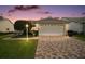 Charming single-story home featuring a brick driveway, well-manicured lawn, and an attached two-car garage at 1007 Diego Ct, The Villages, FL 32159