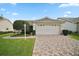 Lovely home showcasing a lush green lawn and a well-maintained brick driveway at 1007 Diego Ct, The Villages, FL 32159