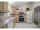 Functional kitchen with white appliances, light wood cabinets, and ample counter space for meal preparation at 1007 Diego Ct, The Villages, FL 32159