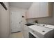 Bright laundry room featuring a washer, dryer, and ample cabinet storage at 1007 Diego Ct, The Villages, FL 32159