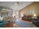 Comfortable living room featuring cozy sofas, a vaulted ceiling, and a large window for natural light at 1007 Diego Ct, The Villages, FL 32159