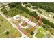 Aerial view of a home showcasing the entire lot with a defined boundary line next to green areas and nearby road at 10128 County Road 229, Oxford, FL 34484