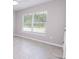 This neutral bedroom features a window with blinds and light gray tile flooring at 10128 County Road 229, Oxford, FL 34484