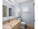 Neat bathroom featuring a mirrored vanity, toilet, and shower with tiled walls and accents at 10161 Sw 87Th Ter, Ocala, FL 34481