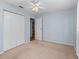 Bedroom with a closet, light blue walls, light colored carpet, and a ceiling fan at 10161 Sw 87Th Ter, Ocala, FL 34481