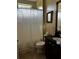 Bathroom with a black granite sink, tiled floor, and shower curtain at 109 Falling Acorn Ave, Groveland, FL 34736