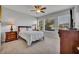 Bright bedroom featuring wood-look floors, a ceiling fan, and large windows with outdoor views at 109 Falling Acorn Ave, Groveland, FL 34736