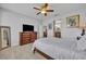 Bright bedroom featuring a ceiling fan, wood floors, and access to the bathroom at 109 Falling Acorn Ave, Groveland, FL 34736