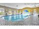 Bright and airy indoor community pool and deck with ample seating and a retractable roof at 109 Falling Acorn Ave, Groveland, FL 34736