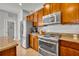 Bright kitchen with wooden cabinets, stainless appliances, granite countertops and a pantry closet at 109 Falling Acorn Ave, Groveland, FL 34736