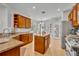 Bright kitchen with wooden cabinets, stainless appliances, granite countertops and access to breakfast nook at 109 Falling Acorn Ave, Groveland, FL 34736