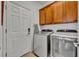 Laundry room featuring wooden cabinets and modern washer and dryer at 109 Falling Acorn Ave, Groveland, FL 34736