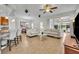Open-concept living room featuring tile floors, neutral decor, and lots of natural light from the sliding doors at 109 Falling Acorn Ave, Groveland, FL 34736